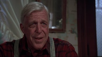 Movie still from “Pet Sematary” (1989), directed by Mary Lambert – An older man wearing a red plaid shirt and suspenders; Close Up shot, Over the shoulder angle