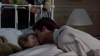 Movie still from “Pet Sematary” (1989), directed by Mary Lambert – A man and a woman laying in a bed kissing; Medium shot, Over the shoulder angle