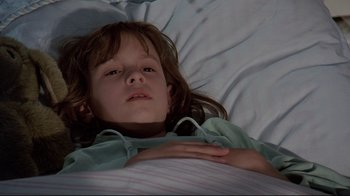 Movie still from “Pet Sematary” (1989), directed by Mary Lambert – A little girl laying in a bed with her head on a pillow; Close Up shot, Low angle