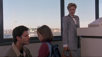 Movie still from “Pet Sematary” (1989), directed by Mary Lambert – A woman in a suit stands in front of two men and a little girl; Medium shot, Over the shoulder angle