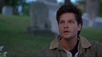 Movie still from “Pet Sematary” (1989), directed by Mary Lambert – A person wearing a jacket near a grave; Close Up shot, Low angle