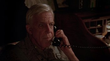 Movie still from “Pet Sematary” (1989), directed by Mary Lambert – An older man talking on a phone while sitting in a chair; Close Up shot, Low angle