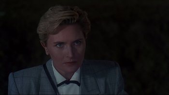 Movie still from “Pet Sematary” (1989), directed by Mary Lambert – A woman with blonde hair wearing a suit and tie; Close Up shot, Over the shoulder angle