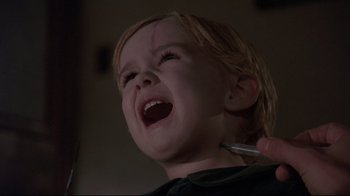 Movie still from “Pet Sematary” (1989), directed by Mary Lambert – A young child is crying while holding a toothbrush; Close Up shot, High angle