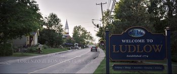 Movie still from “Pet Sematary” (2019), directed by Kevin Kölsch – A car driving down a street next to a church; Extreme Wide shot, Low angle