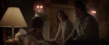 Movie still from “Pet Sematary” (2019), directed by Kevin Kölsch – A woman sitting on a bed next to a man and a little girl; Medium shot, Over the shoulder angle