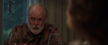 Movie still from “Pet Sematary” (2019), directed by Kevin Kölsch – An older man sitting at a table with a glass of wine; Close Up shot, Over the shoulder angle