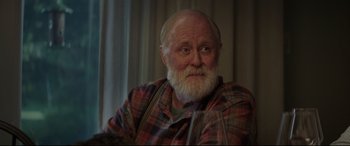Movie still from “Pet Sematary” (2019), directed by Kevin Kölsch – An old man with a beard and a mustache wearing a plaid shirt; Close Up shot, Over the shoulder angle