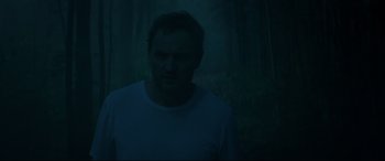 Movie still from “Pet Sematary” (2019), directed by Kevin Kölsch – A man standing in the dark in front of a forest; Medium shot, Low angle
