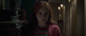 Movie still from “Pet Sematary” (2019), directed by Kevin Kölsch – A little girl with long red hair is looking at the camera; Close Up shot, Over the shoulder angle