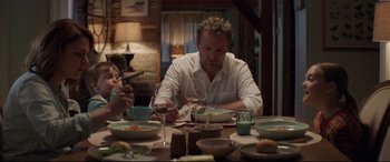 Movie still from “Pet Sematary” (2019), directed by Kevin Kölsch – A man sitting at a table with a plate of food; Medium shot, Over the shoulder angle