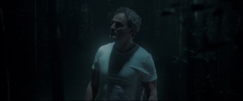 Movie still from “Pet Sematary” (2019), directed by Kevin Kölsch – A man standing in the dark in front of a forest; Medium shot, Low angle
