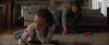 Movie still from “Pet Sematary” (2019), directed by Kevin Kölsch – A man and a woman playing a game on the floor; Medium shot, Over the shoulder angle