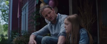 Movie still from “Pet Sematary” (2019), directed by Kevin Kölsch – A man sitting next to a little girl in front of balloons; Close Up shot, Over the shoulder angle