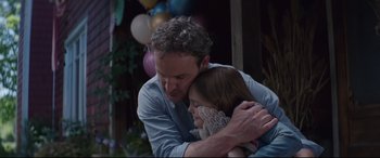 Movie still from “Pet Sematary” (2019), directed by Kevin Kölsch – A man and a woman hugging each other in front of balloons; Medium shot, Over the shoulder angle