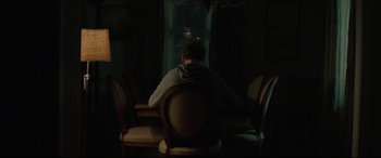 Movie still from “Pet Sematary” (2019), directed by Kevin Kölsch – A man sitting at a table in front of a window; Medium shot, Over the shoulder angle