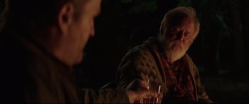 Movie still from “Pet Sematary” (2019), directed by Kevin Kölsch – Two men sitting at a table with glasses of wine; Medium shot, Over the shoulder angle