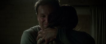 Movie still from “Pet Sematary” (2019), directed by Kevin Kölsch – A man and a woman hugging in a dark room; Close Up shot, Over the shoulder angle