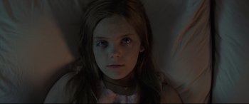 Movie still from “Pet Sematary” (2019), directed by Kevin Kölsch – A young girl with long brown hair stares into the camera; Close Up shot, High angle