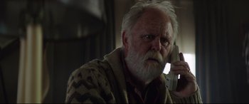 Movie still from “Pet Sematary” (2019), directed by Kevin Kölsch – An old man with a beard and a mustache is talking on the phone; Close Up shot, Low angle