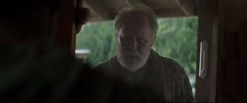 Movie still from “Pet Sematary” (2019), directed by Kevin Kölsch – An old man with a beard is looking into the distance; Close Up shot, Over the shoulder angle