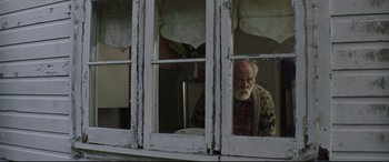 Movie still from “Pet Sematary” (2019), directed by Kevin Kölsch – An older man looking out of a window; Medium shot, Low angle