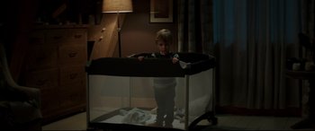 Movie still from “Pet Sematary” (2019), directed by Kevin Kölsch – A little boy standing inside of a baby crib; Medium shot, High angle
