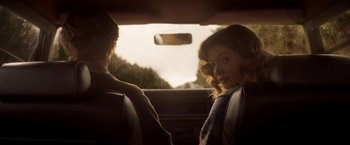 Movie still from “Pete's Dragon” (2016), directed by David Lowery – A woman sitting in the passenger seat of a car next to a man; Medium shot, Over the shoulder angle