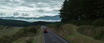Movie still from “Pete's Dragon” (2016), directed by David Lowery – A truck driving down a road near a forest; Extreme Wide shot, Low angle
