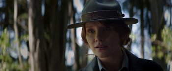 Movie still from “Pete's Dragon” (2016), directed by David Lowery – A person wearing a hat with trees in the background; Close Up shot, Low angle