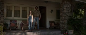Movie still from “Pete's Dragon” (2016), directed by David Lowery – A man and a woman standing in front of a house; Wide shot, Low angle