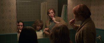 Movie still from “Pete's Dragon” (2016), directed by David Lowery – A woman brushing her teeth in a bathroom mirror; Medium shot, Over the shoulder angle