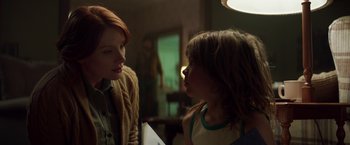 Movie still from “Pete's Dragon” (2016), directed by David Lowery – Two young people are talking to each other in a dimly - lit room; Medium shot, Over the shoulder angle