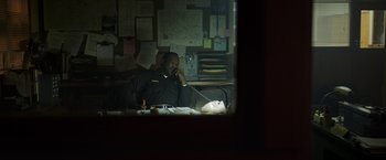 Movie still from “Pete's Dragon” (2016), directed by David Lowery – A man sitting at a desk talking on the phone; Medium shot, Over the shoulder angle