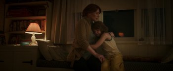A woman and a child are hugging in a room