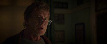 Movie still from “Pete's Dragon” (2016), directed by David Lowery – An older man wearing glasses looking at the camera; Close Up shot, Over the shoulder angle