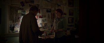 Movie still from “Pete's Dragon” (2016), directed by David Lowery – Two people standing in front of a wall covered with papers; Medium shot, Over the shoulder angle