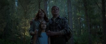 Movie still from “Pete's Dragon” (2016), directed by David Lowery – A man and a woman and a girl are standing in the woods; Medium shot, Low angle