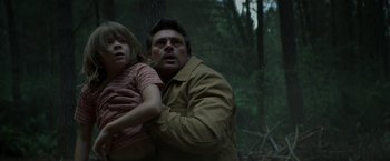 Movie still from “Pete's Dragon” (2016), directed by David Lowery – A man and a girl in the woods with trees in the background; Medium shot, Low angle