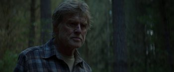Movie still from “Pete's Dragon” (2016), directed by David Lowery – An older man in a plaid shirt in the woods; Close Up shot, Over the shoulder angle