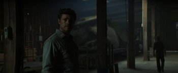 Movie still from “Pete's Dragon” (2016), directed by David Lowery – A man standing in the dark in front of a window; Medium shot, Low angle