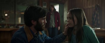 Movie still from “Pete's Dragon” (2016), directed by David Lowery – A man touching a woman's face in front of another woman; Close Up shot, Over the shoulder angle