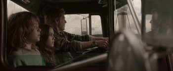 Movie still from “Pete's Dragon” (2016), directed by David Lowery – A man and a woman sitting in the drivers seat of a truck; Medium shot, Over the shoulder angle