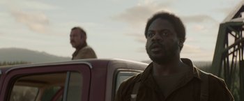 Movie still from “Pete's Dragon” (2016), directed by David Lowery – Two men standing next to each other in front of a red truck; Close Up shot, Over the shoulder angle