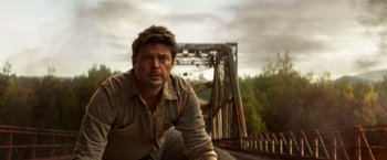 Movie still from “Pete's Dragon” (2016), directed by David Lowery – A man sitting on the side of a bridge; Close Up shot, Low angle