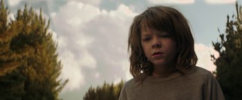 Movie still from “Pete's Dragon” (2016), directed by David Lowery – A young girl is standing in front of a forest; Close Up shot, Low angle