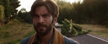 Movie still from “Pete's Dragon” (2016), directed by David Lowery – A man with a beard standing in front of a green dragon; Close Up shot, Over the shoulder angle