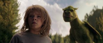 Movie still from “Pete's Dragon” (2016), directed by David Lowery – A young boy with long blonde hair standing in front of a green creature; Close Up shot, Low angle