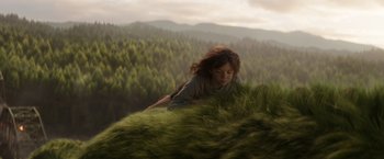 Movie still from “Pete's Dragon” (2016), directed by David Lowery – A woman laying on top of a grass covered hill; Wide shot, Low angle