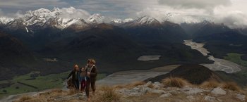 Movie still from “Pete's Dragon” (2016), directed by David Lowery – A group of people standing on top of a mountain; Extreme Wide shot, High angle